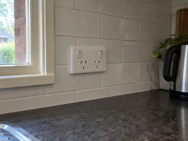 White double power point on tiled kitchen splashback beside a window and benchtop in Ourimbah
